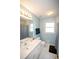 Bathroom with light blue walls, white tile flooring and checker patterned shower curtain at 1030 E Lakehaven Way, Mcdonough, GA 30253