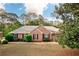 Charming brick ranch with well-manicured lawn, mature trees, and inviting front entrance at 1030 E Lakehaven Way, Mcdonough, GA 30253