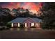 Inviting brick ranch home illuminated at dusk, showcasing the landscaped yard and curb appeal at 1030 E Lakehaven Way, Mcdonough, GA 30253