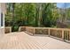 Inviting back deck with wood flooring, railing, and peaceful views of the surrounding trees at 4423 Windsor Oaks Cir, Marietta, GA 30066