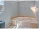 Bathroom featuring a built-in tub with tile surround and neutral color scheme at 4423 Windsor Oaks Cir, Marietta, GA 30066