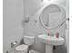 Simple powder room with pedestal sink, round mirror, and neutral color scheme at 4423 Windsor Oaks Cir, Marietta, GA 30066