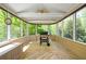 Relaxing screened porch with a grill, ceiling fans, bench seating, and views of the lush landscape at 4423 Windsor Oaks Cir, Marietta, GA 30066