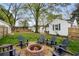Backyard with lawn, firepit, mature trees, wooden benches and a home in the background at 502 Allgood Ne Rd, Marietta, GA 30060