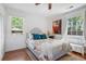 Well-lit bedroom with hardwood floors, two large windows, a bench and a large bed at 502 Allgood Ne Rd, Marietta, GA 30060