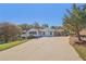Charming one-story home featuring a covered carport, a brick chimney and a long cracked driveway at 6684 Birch Rd, Winston, GA 30187