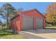 Exterior view of a two-car garage with red siding and gray doors at 6684 Birch Rd, Winston, GA 30187