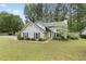 Well-maintained exterior view of home with lush green lawn, driveway, mature trees, and inviting front entrance at 100 Karla Ct, Roswell, GA 30076