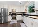 Well-lit kitchen features stainless steel appliances, tile backsplash, and dark hardwood floors at 100 Karla Ct, Roswell, GA 30076