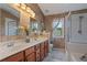 The bathroom features double sinks, an updated tub and shower combo and an accent wall at 327 Stone Valley Xing, Canton, GA 30114