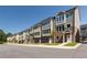 Row of townhomes with stone accents and gray siding, set along a freshly paved street and manicured lawns at 3806 Jack Vernon Cir, Powder Springs, GA 30127