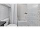 Bathroom featuring a toilet, tub with shower, and patterned wall covering at 923 Peachtree Ne St # 1625, Atlanta, GA 30309