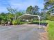 View of a metal carport structure set on a paved driveway with surrounding greenery at 1025 Rocky Plains Rd, Covington, GA 30016