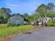 A storage shed with a side overhang on a paved driveway with lawn equipment parked nearby at 1025 Rocky Plains Rd, Covington, GA 30016