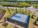 Aerial view of a fenced outdoor basketball court with blue accents and surrounding landscape at 10686 Austen Bnd, Alpharetta, GA 30022