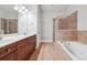 Bathroom featuring a double vanity, soaking tub, and glass enclosed shower at 10686 Austen Bnd, Alpharetta, GA 30022