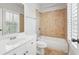 Bathroom with tile surround tub, and white vanity with sink and mirror at 10686 Austen Bnd, Alpharetta, GA 30022