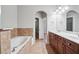 Bathroom featuring a double vanity, soaking tub, and neutral tiles at 10686 Austen Bnd, Alpharetta, GA 30022