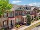 Townhomes featuring red brick facades, individual covered entrances, and lush landscaping at 10686 Austen Bnd, Alpharetta, GA 30022