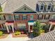 Charming townhome with a well-maintained brick facade, a manicured lawn and a red front door at 10686 Austen Bnd, Alpharetta, GA 30022