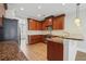 Modern kitchen featuring wood cabinets, granite countertops, and stainless steel appliances at 10686 Austen Bnd, Alpharetta, GA 30022