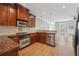 Well-equipped kitchen with stainless steel appliances, dark wood cabinetry and granite countertops at 10686 Austen Bnd, Alpharetta, GA 30022