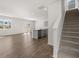 Open-concept living room with hardwood floors, staircase, and a kitchen island at 8234 Coldstream Dr, Fairburn, GA 30213