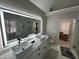 Modern bathroom featuring double sinks, a large LED mirror, a glass-enclosed shower and a toilet at 2657 Mcguire Nw Dr, Kennesaw, GA 30144