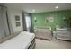 Bright Bedroom featuring calming green tones, framed artwork, a crib, and a comfortable daybed at 2657 Mcguire Nw Dr, Kennesaw, GA 30144