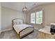 Cozy bedroom with plush carpeting, a stylish light fixture, and a window that lets in natural light at 3460 Montebello Pkwy, Cumming, GA 30028