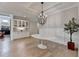 A dining room with a modern chandelier, wainscoting, and a sleek oval table at 3460 Montebello Pkwy, Cumming, GA 30028