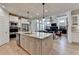 Open kitchen with granite island, stainless steel appliances, and hardwood flooring overlooking the living area at 3460 Montebello Pkwy, Cumming, GA 30028