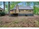 Exterior backyard view featuring a wood siding, walkout deck, and lovely landscaping at 6693 Doublegate Ln, Rex, GA 30273