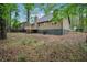 A charming backyard view featuring lush trees, a wood deck, and lovely lawn at 6693 Doublegate Ln, Rex, GA 30273