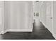 Hallway featuring dark wood floors and light gray walls with white trim and doors at 990 Lilac Arbor Rd, Dacula, GA 30019