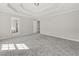 Spacious main bedroom with carpet and tray ceiling leading to ensuite bathroom at 990 Lilac Arbor Rd, Dacula, GA 30019