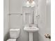 Stylish powder room featuring a pedestal sink, modern fixtures, and neutral tones at 990 Lilac Arbor Rd, Dacula, GA 30019