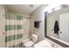 Bright bathroom featuring a shower-tub combo with blue striped curtain and a mirror over the vanity at 1354 Benbrooke Nw Ln, Acworth, GA 30101