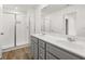 Bathroom with double vanity, gray cabinets, walk-in shower with tiled walls, and large mirror at 229 Kenoot Dr # 49, Mcdonough, GA 30253