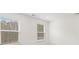 Well-lit bedroom with two windows featuring views of the wooded yard and blinds at 229 Kenoot Dr # 49, Mcdonough, GA 30253