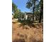 Backyard with trees, landscaping, freshly laid pine straw, and partial view of the house at 3089 Corbin Ave, Decatur, GA 30034