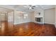 Open-concept living area with hardwood floors, a stone fireplace, and views to the kitchen and dining areas at 4360 Carver Ct, Cumming, GA 30040