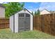 Backyard featuring a gray outdoor storage shed, green grass, and a wooden fence at 4360 Carver Ct, Cumming, GA 30040