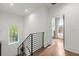 Upstairs hallway with modern railing and hardwood floors leading to bedrooms and bathrooms at 479 Clifton Se St, Atlanta, GA 30316