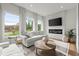 Sun-filled living room featuring modern sofas, large windows, and a stylish fireplace at 479 Clifton Se St, Atlanta, GA 30316