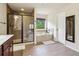 Bathroom featuring a large shower with glass doors, separate tub, tile flooring and modern fixtures at 4970 Roseman Trl, Cumming, GA 30040