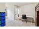 Bedroom with neutral carpet, white walls, desk, and access to another room via an open door at 4970 Roseman Trl, Cumming, GA 30040