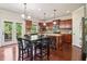Bright kitchen with cherry cabinets, granite countertops, stainless appliances, an island and an adjacent breakfast area at 4970 Roseman Trl, Cumming, GA 30040