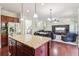 Open-concept kitchen featuring stainless appliances, granite counters, a dining area, and a living room with entertainment center at 4970 Roseman Trl, Cumming, GA 30040