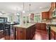 Open-concept kitchen featuring stainless appliances, granite counters, cherry cabinets and breakfast area and an adjacent living room at 4970 Roseman Trl, Cumming, GA 30040